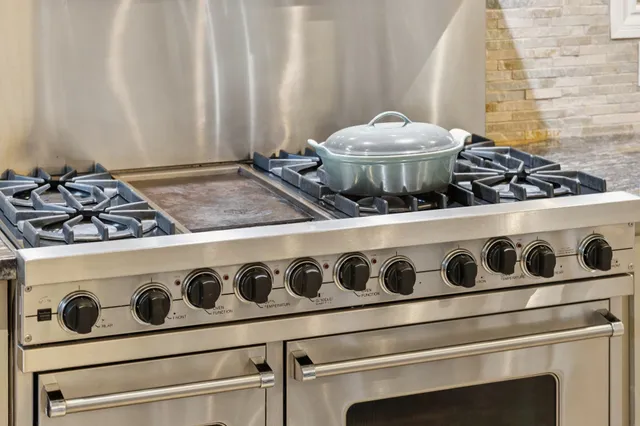 a kitchen with stainless steel appliances granite countertop a stove and a sink
