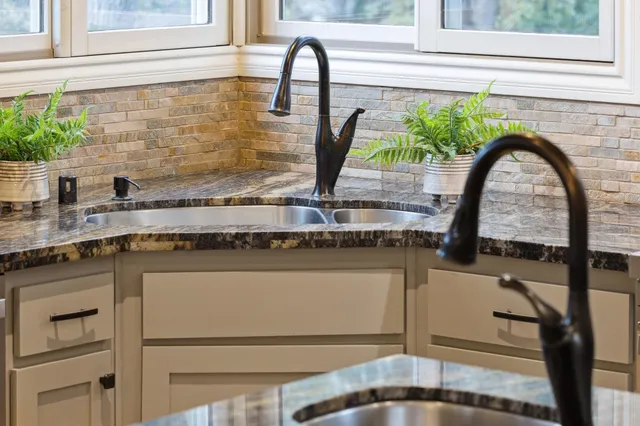 a kitchen with stainless steel appliances granite countertop a sink stove and cabinets