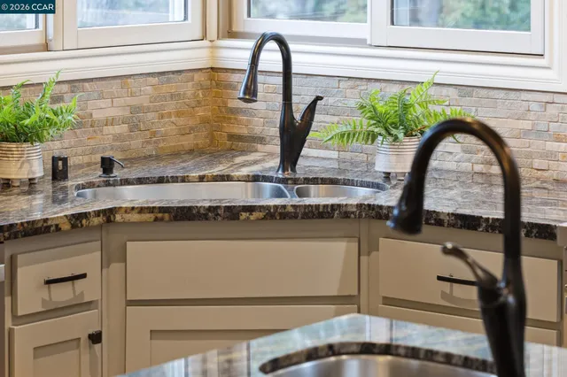 a kitchen with stainless steel appliances granite countertop a sink stove and cabinets