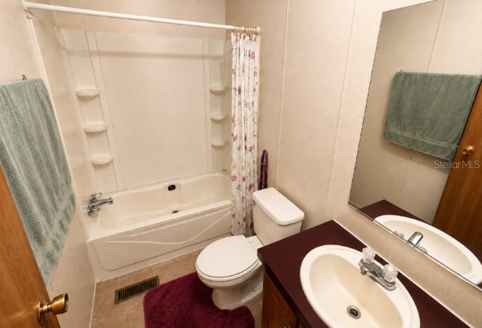 1142 Southwest Jim Clark Road Madison, FL 32340 - Photo 6 of 14 a white toilet sitting next to a bathroom sink and a shower