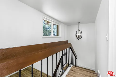 a view of staircase with wooden floor and window