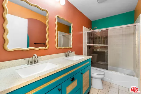 a bathroom with a sink a toilet a mirror and shower