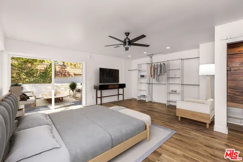 a spacious bedroom with a bed and a view of balcony