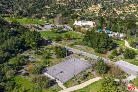 a view of a house with a lush green forest