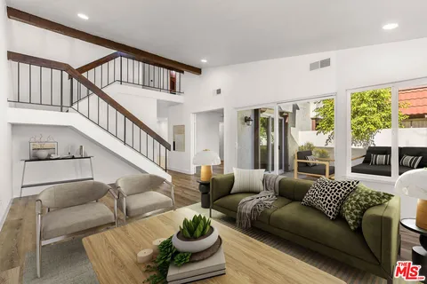 a living room with furniture fireplace and a large window