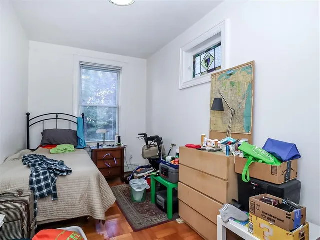 a bedroom with a bed and painting on the wall