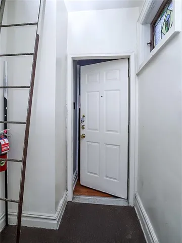a view of an empty room with wooden floor and closet
