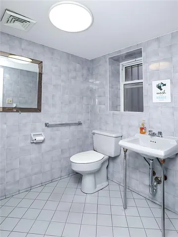 a bathroom with a sink a toilet and mirror