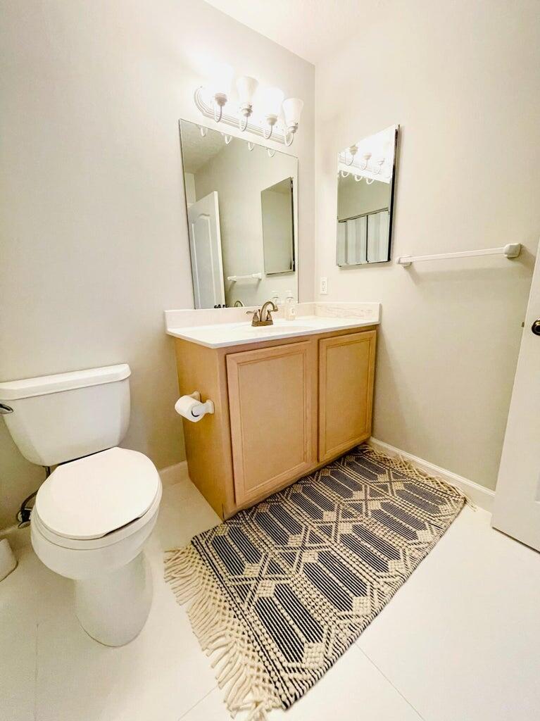 1420 Ocean Way, Unit 32C Jupiter, FL 33477 - Photo 18 of 22 a bathroom with a toilet sink and mirror