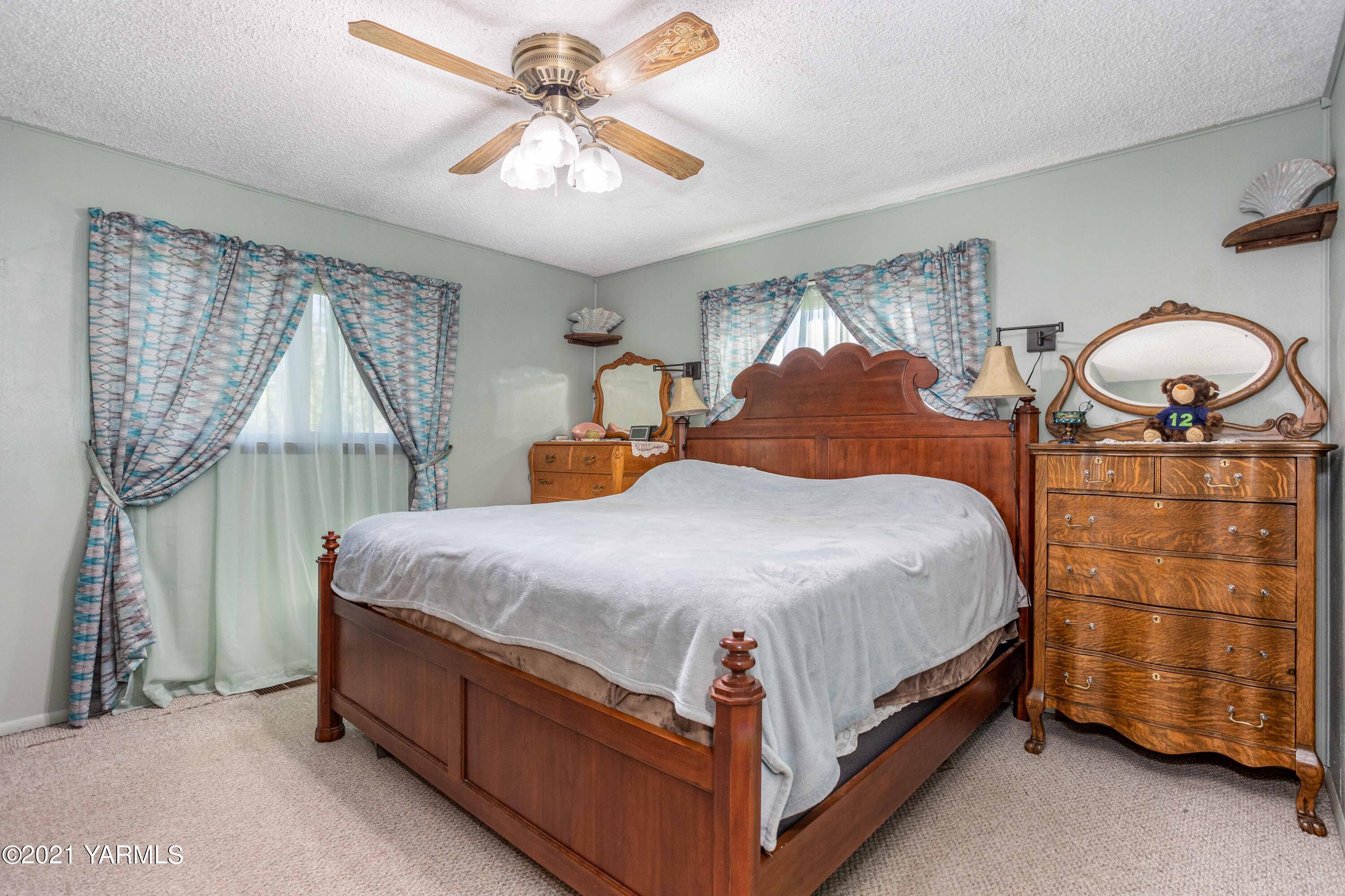 800 Blaine Road Granger, WA 98932 - Photo 11 of 43 a bedroom with a bed a lamp and a chandelier