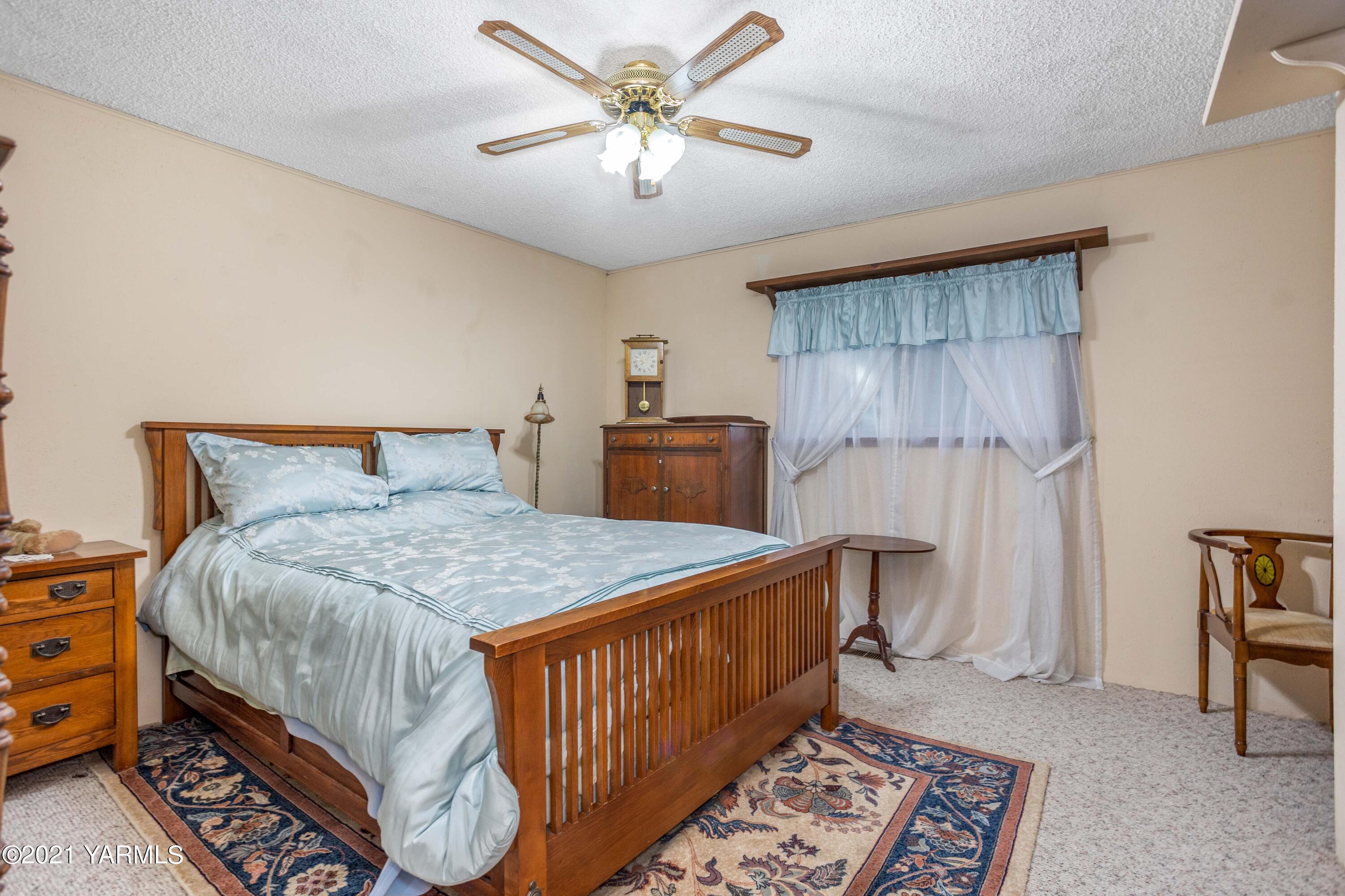 800 Blaine Road Granger, WA 98932 - Photo 12 of 43 a bedroom with a bed and a chandelier