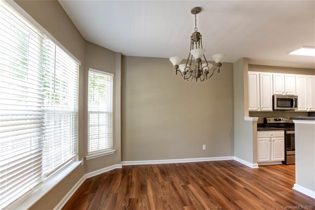 2515 Fossil Stone Lane Fort Mill, SC 29708 - Photo 14 of 37 a view of a room with wooden floor chandelier and a kitchen