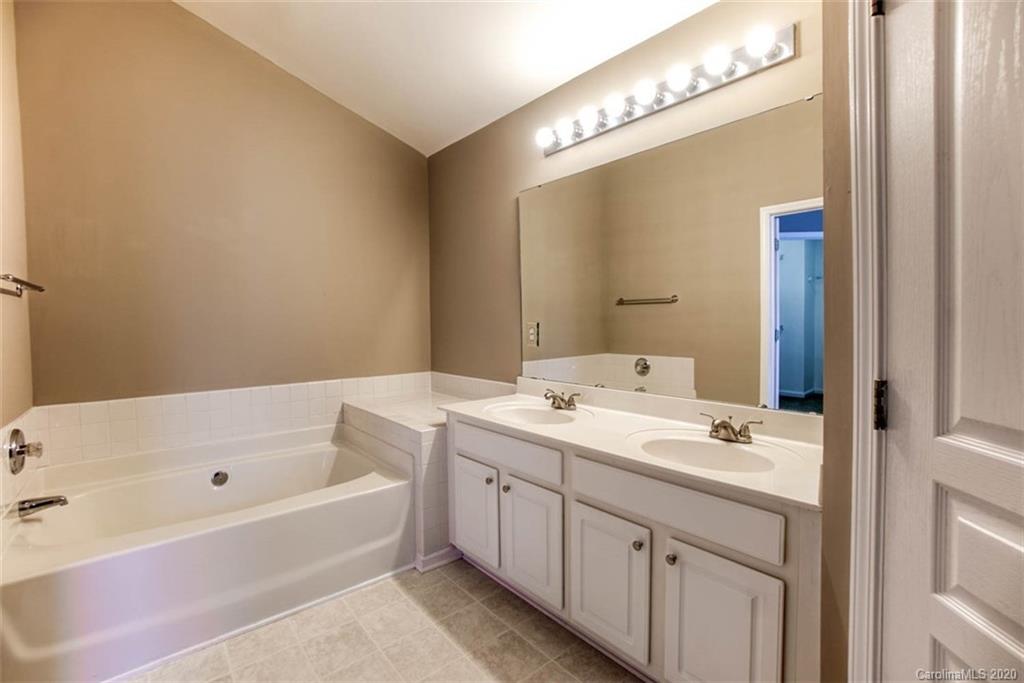 2515 Fossil Stone Lane Fort Mill, SC 29708 - Photo 32 of 37 a bathroom with a tub sink and mirror