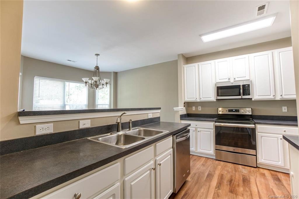 2515 Fossil Stone Lane Fort Mill, SC 29708 - Photo 8 of 37 a kitchen with stainless steel appliances granite countertop a sink a stove a microwave and wooden cabinets