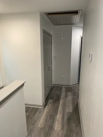 a view of a room with wooden floor and mirror
