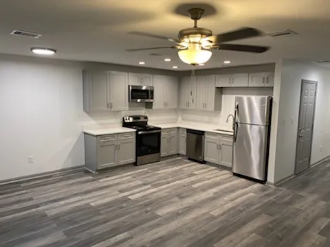 a kitchen with stainless steel appliances granite countertop a sink refrigerator stove and microwave