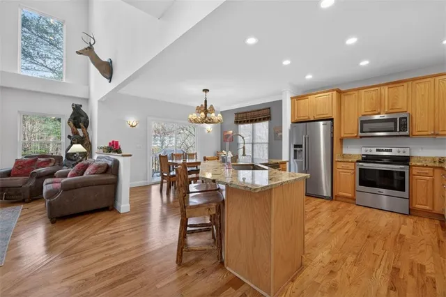 a kitchen with stainless steel appliances granite countertop a oven a stove and a wooden floors