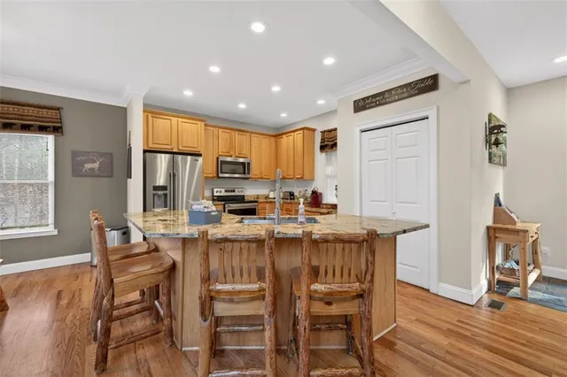 a kitchen with stainless steel appliances granite countertop a stove a sink and a refrigerator