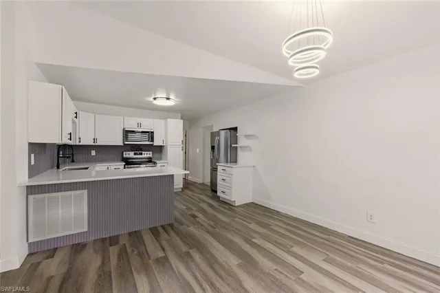 a kitchen with a refrigerator and white cabinets