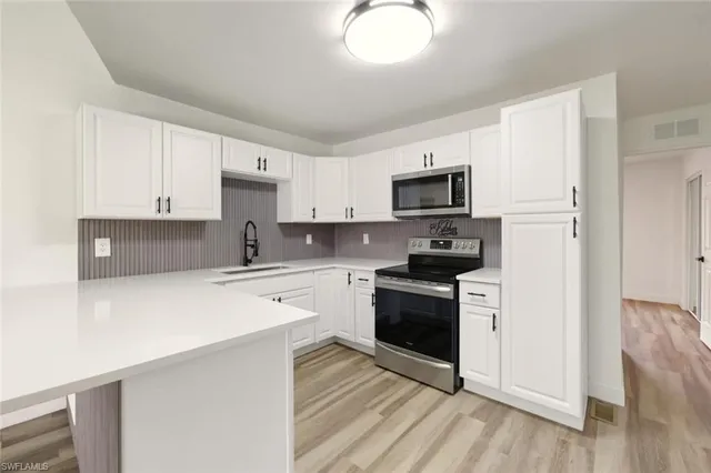 a kitchen with stainless steel appliances a refrigerator sink and stove