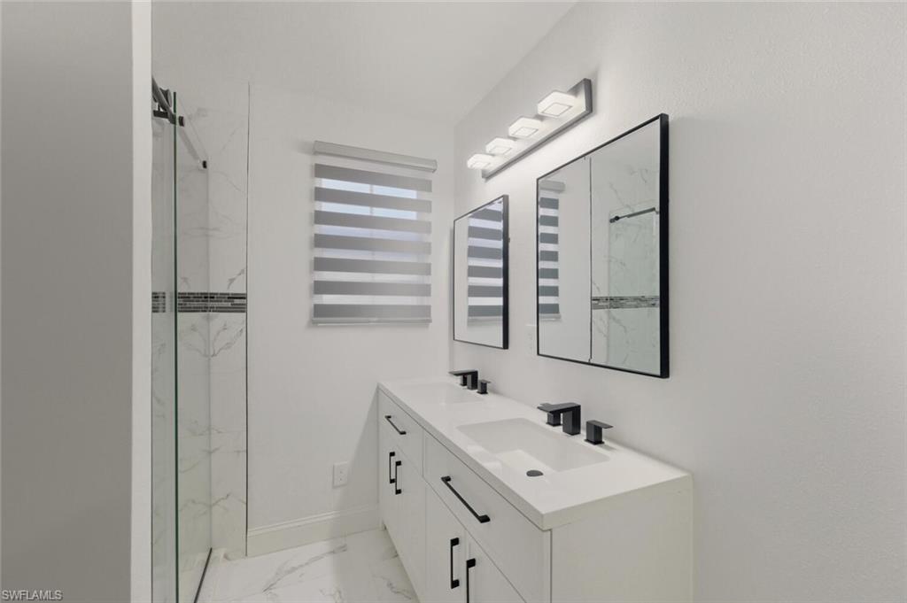5317 Dixie Drive Naples, FL 34113 - Photo 18 of 36 a bathroom with a sink and a mirror