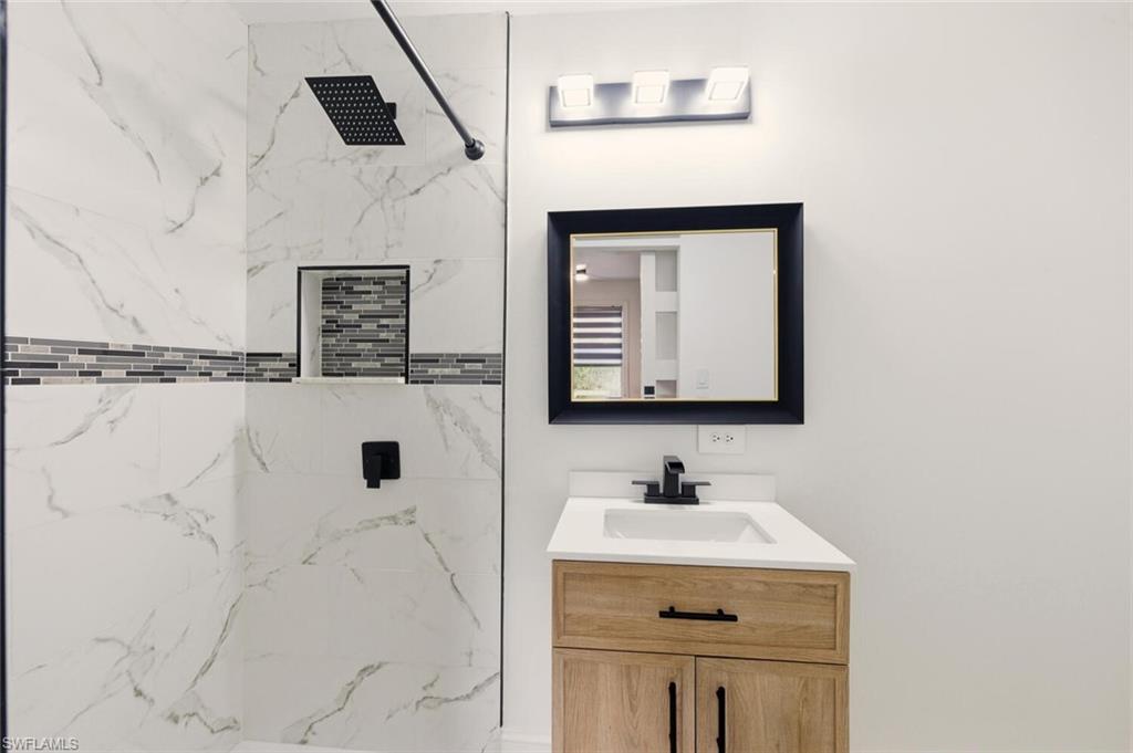 5317 Dixie Drive Naples, FL 34113 - Photo 22 of 36 a bathroom with a sink and a mirror