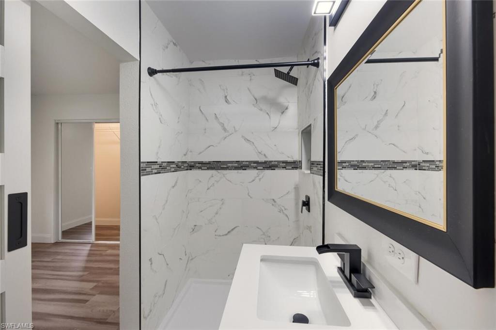 5317 Dixie Drive Naples, FL 34113 - Photo 23 of 36 a bathroom with a sink a glass door shower and vanity