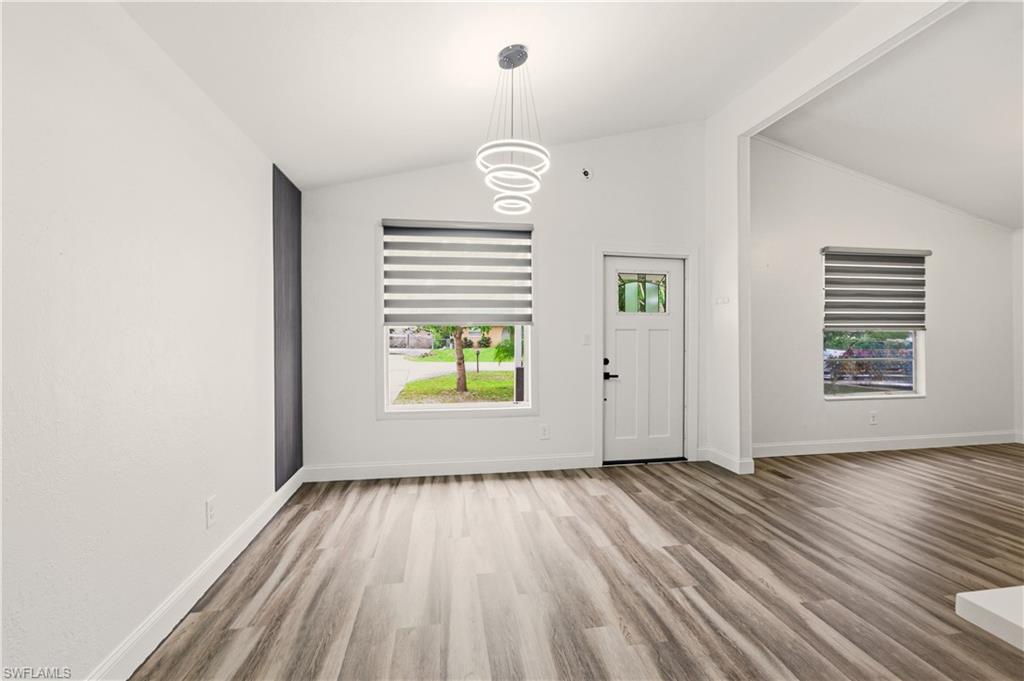 5317 Dixie Drive Naples, FL 34113 - Photo 5 of 36 a view of an empty room with wooden floor and a window