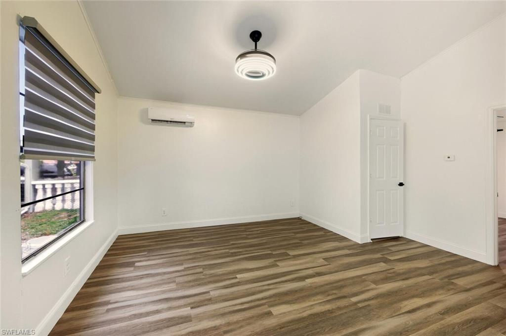5317 Dixie Drive Naples, FL 34113 - Photo 6 of 36 an empty room with wooden floor and windows