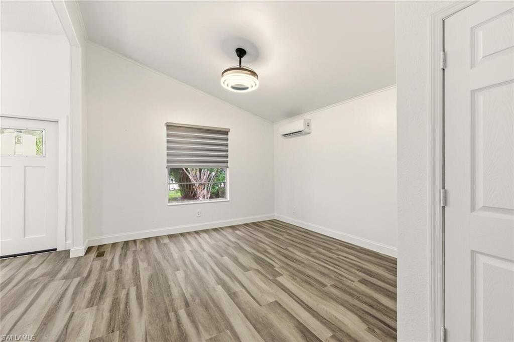5317 Dixie Drive Naples, FL 34113 - Photo 7 of 36 an empty room with wooden floor and windows
