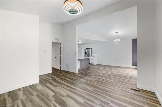 a view of empty room with wooden floor