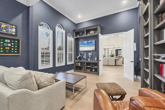 a living room with furniture a bookshelf and a window