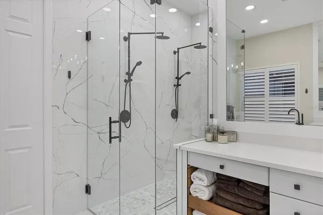 a large bathroom with a granite countertop sink a large mirror and shower