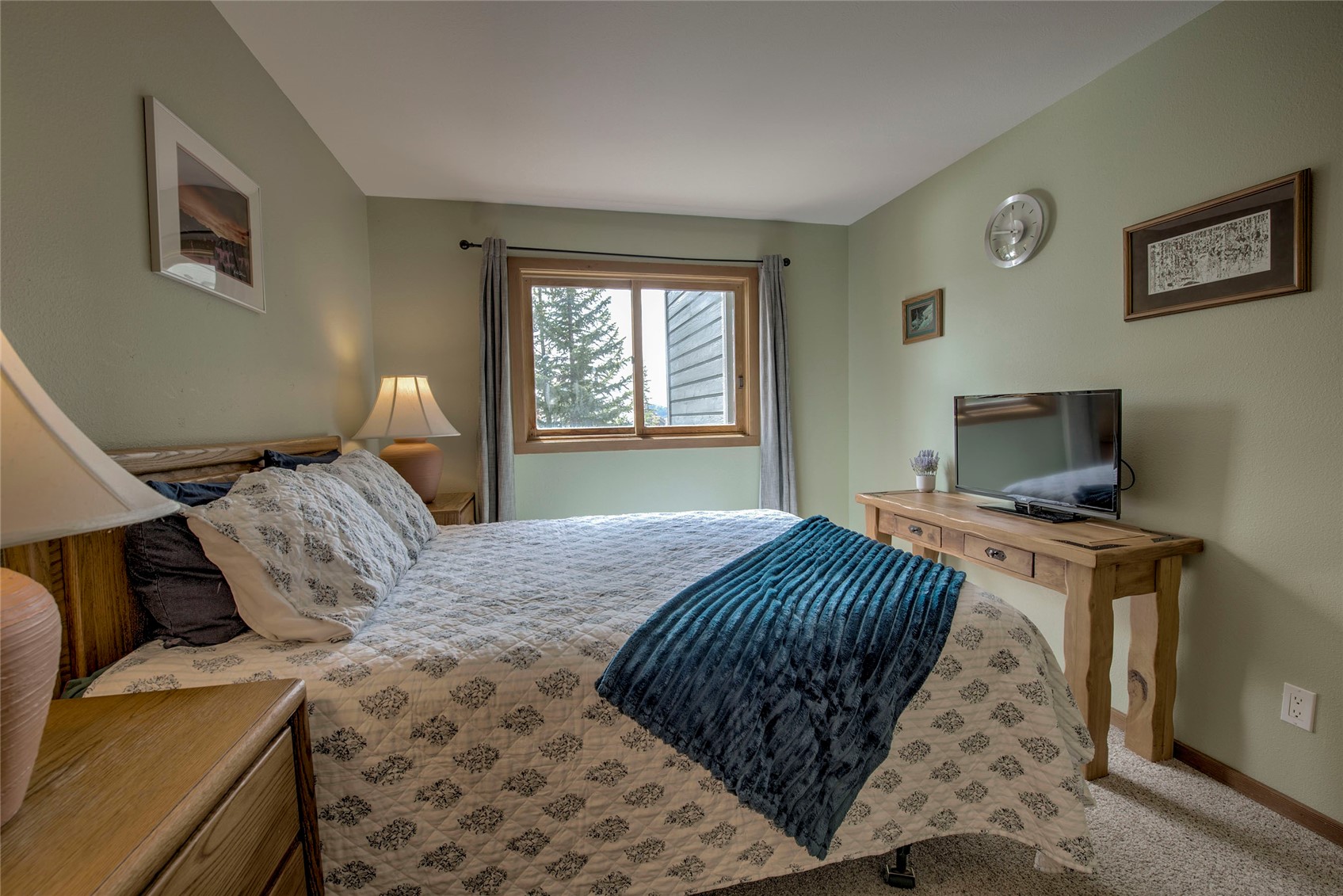 94300 Ryan Gulch Road, Unit 301 Silverthorne, CO 80498 - Photo 11 of 35 a bedroom with a bed and a flat screen tv