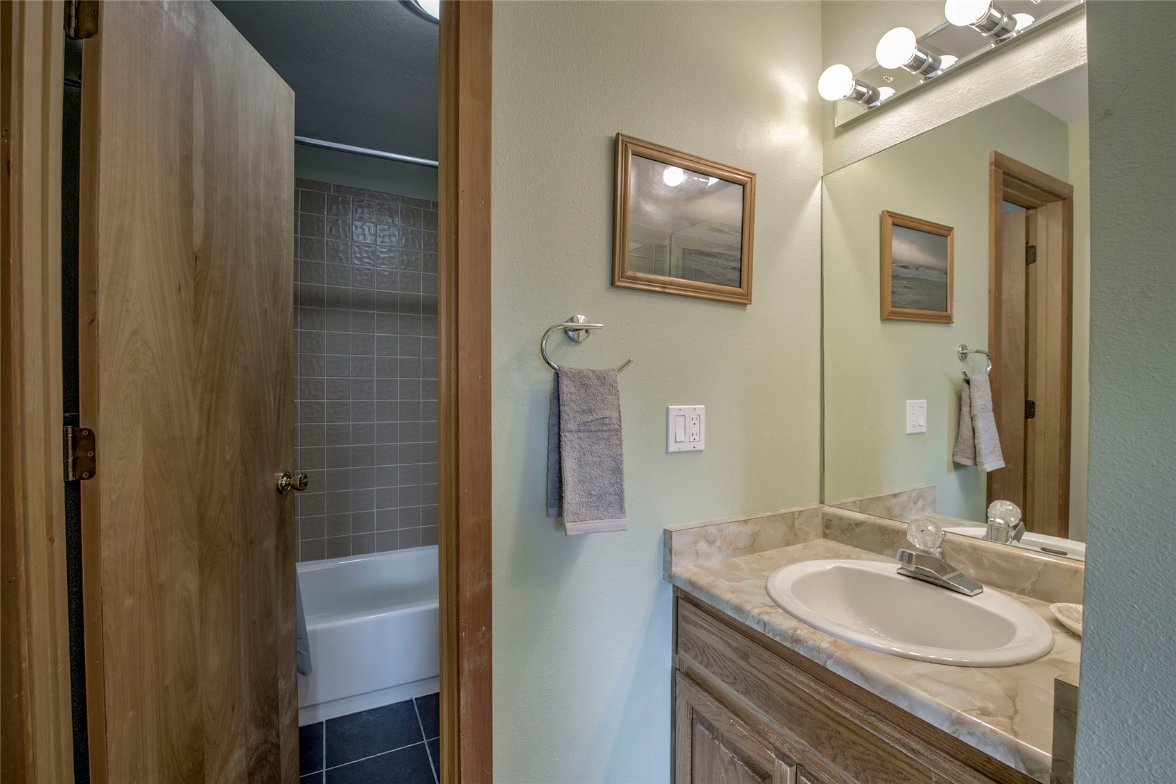 94300 Ryan Gulch Road, Unit 301 Silverthorne, CO 80498 - Photo 13 of 35 a bathroom with a granite countertop sink a mirror and shower