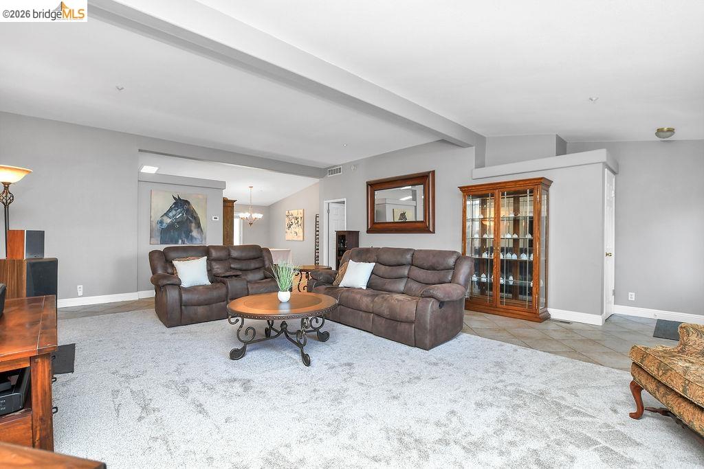 4229 Briones Valley Road Brentwood, CA 94513 - Photo 14 of 37 Living room featuring vaulted ceiling with beams, light tile patterned floors, and light colored carpet