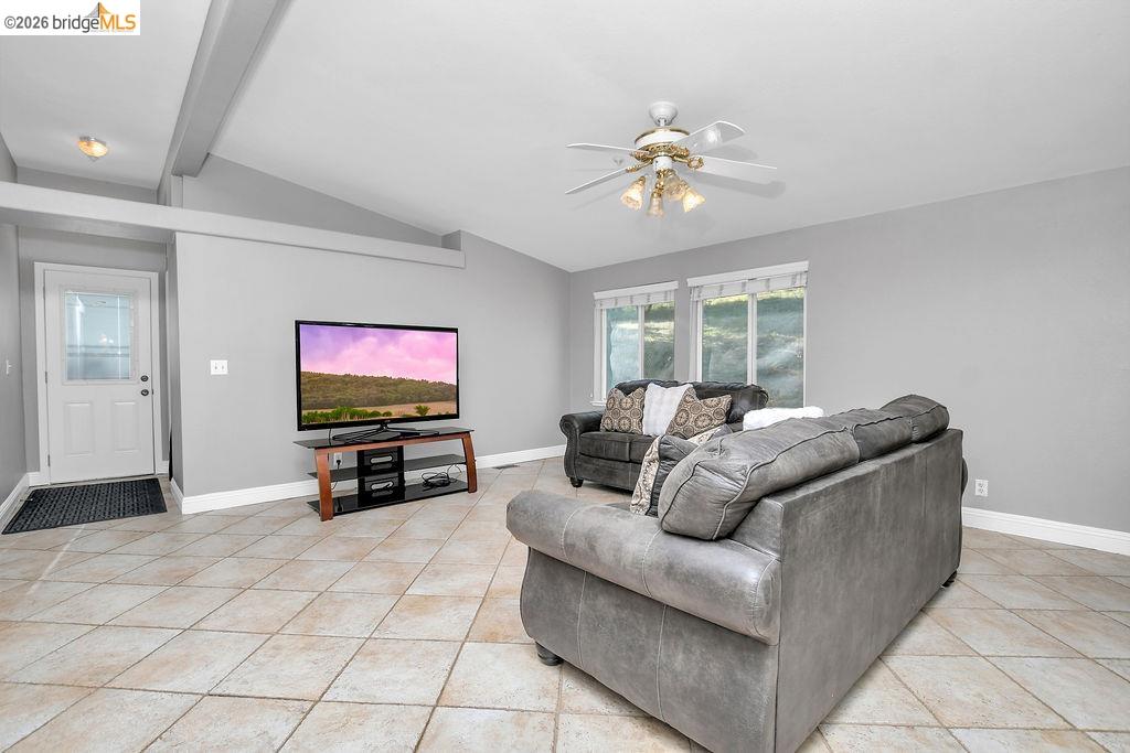 4229 Briones Valley Road Brentwood, CA 94513 - Photo 16 of 37 Living area with ceiling fan, light tile patterned floors, and vaulted ceiling