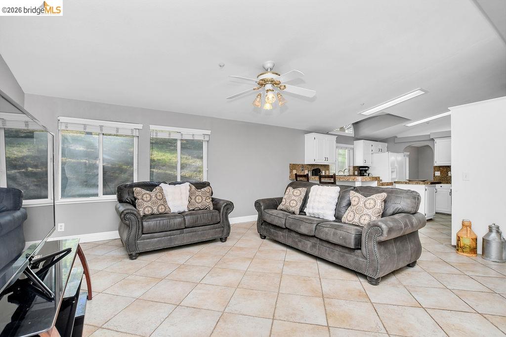 4229 Briones Valley Road Brentwood, CA 94513 - Photo 17 of 37 Living room with a ceiling fan, light tile patterned flooring, and arched walkways