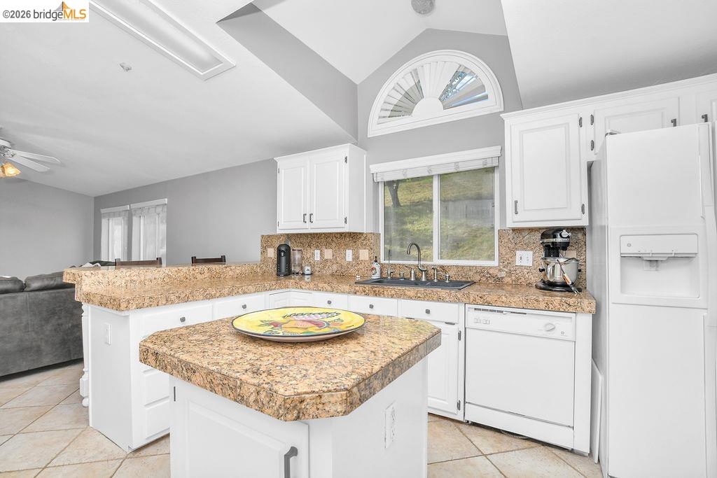 4229 Briones Valley Road Brentwood, CA 94513 - Photo 19 of 37 Kitchen with white appliances, lofted ceiling, decorative backsplash, and white cabinetry