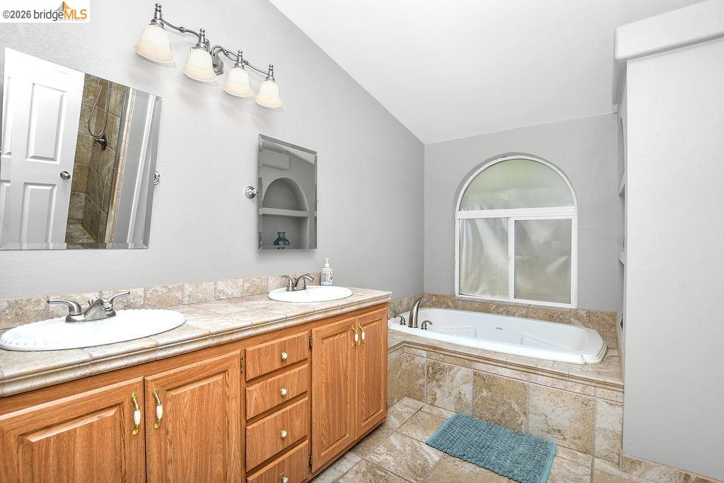 4229 Briones Valley Road Brentwood, CA 94513 - Photo 27 of 37 Bathroom featuring double vanity, a garden tub, and lofted ceiling