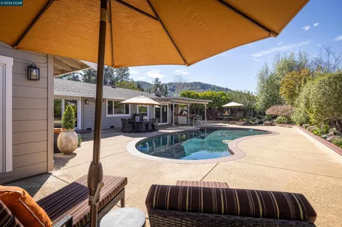 a view of a house with swimming pool and sitting area