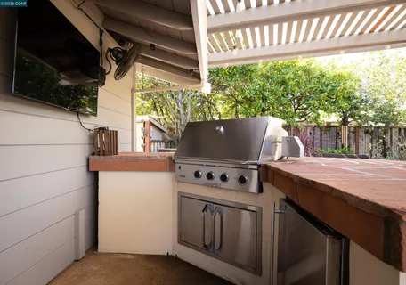 a view of a patio with table and chairs under an umbrella
