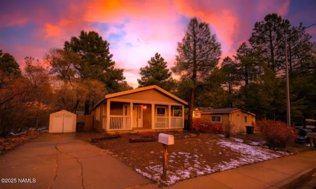 a front view of a house with yard and trees