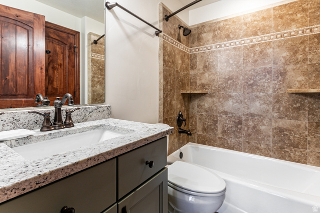 5326 North Oldgate Road Heber City, UT 84032 - Photo 24 of 32 Bathroom featuring a granite countertop vanity with an undermount sink, a bronze-finish faucet, and coordinating dark cabinetry