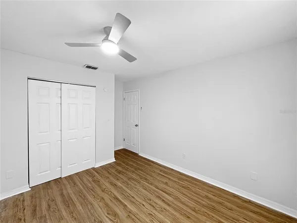 a view of empty room with wooden floor
