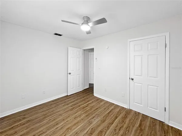 a view of an empty room with wooden floor