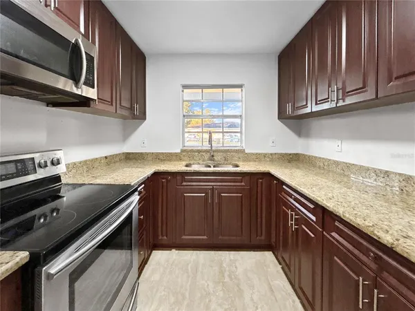 a kitchen with a sink stove and microwave