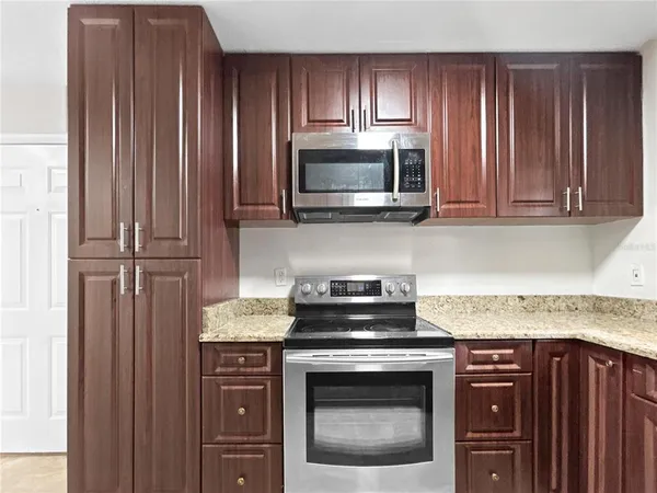 a kitchen with granite countertop wood cabinets and stainless steel appliances