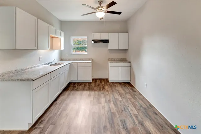 a kitchen with sink and cabinets