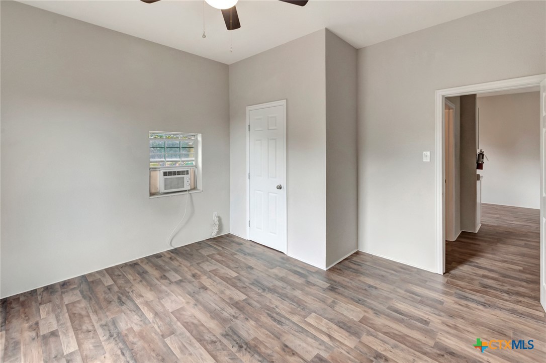 103 5th Street Seadrift, TX 77983 - Photo 14 of 18 an empty room with wooden floor and windows
